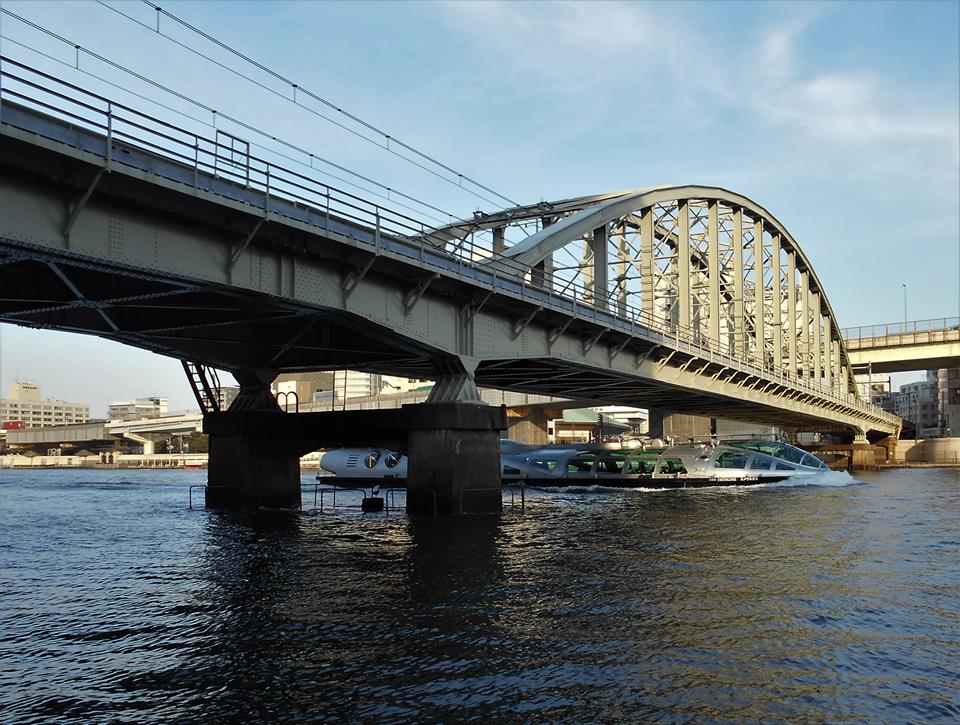 隅田川橋梁の下を水上バスのホタルナが通過する画像